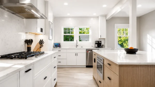Bright remodeled kitchen in a century old Seattle home with white cabinetry, a wood island, quartz countertops, and stainless steel appliances.