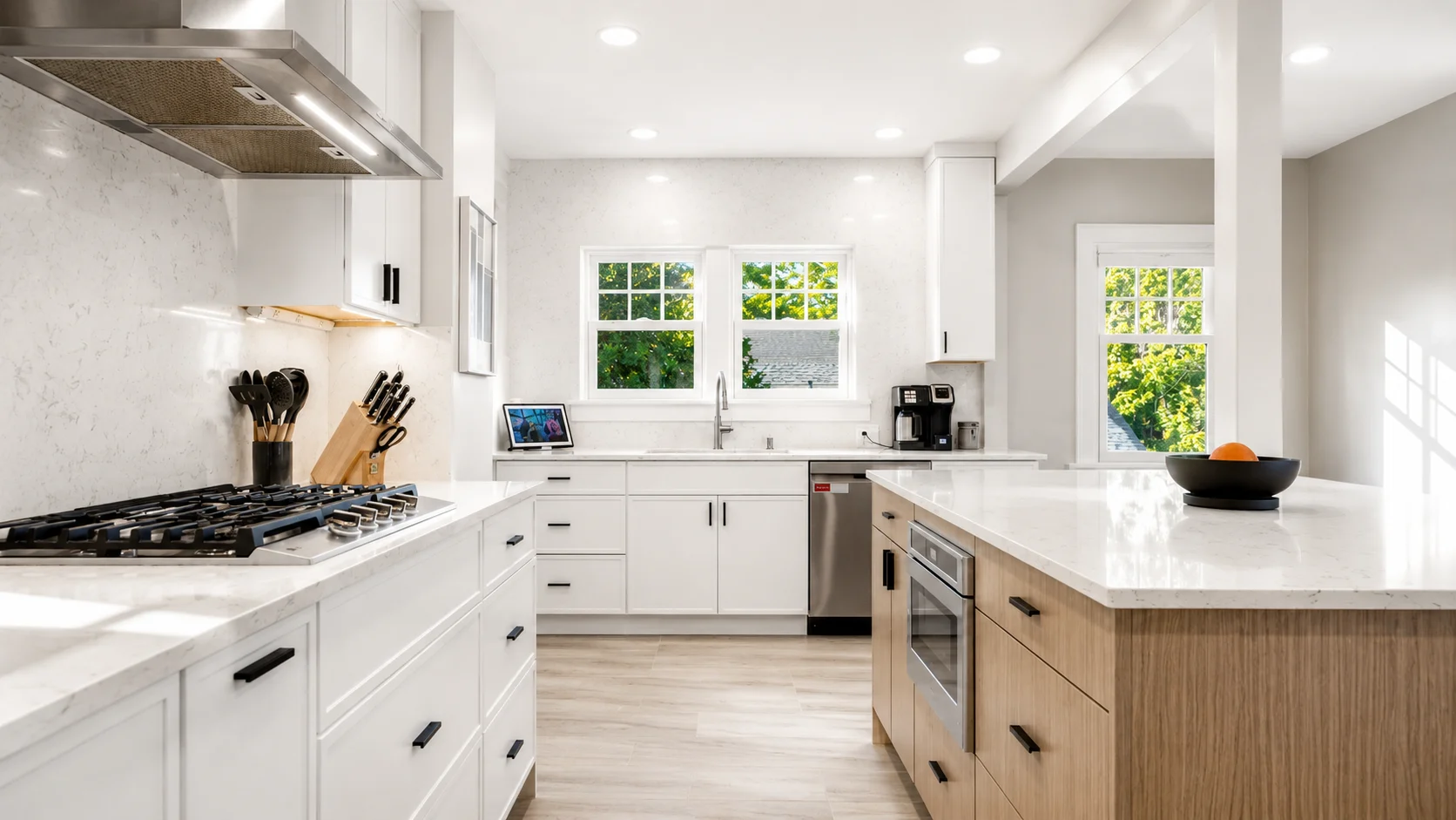 Bright remodeled kitchen in a century old Seattle home with white cabinetry, a wood island, quartz countertops, and stainless steel appliances.